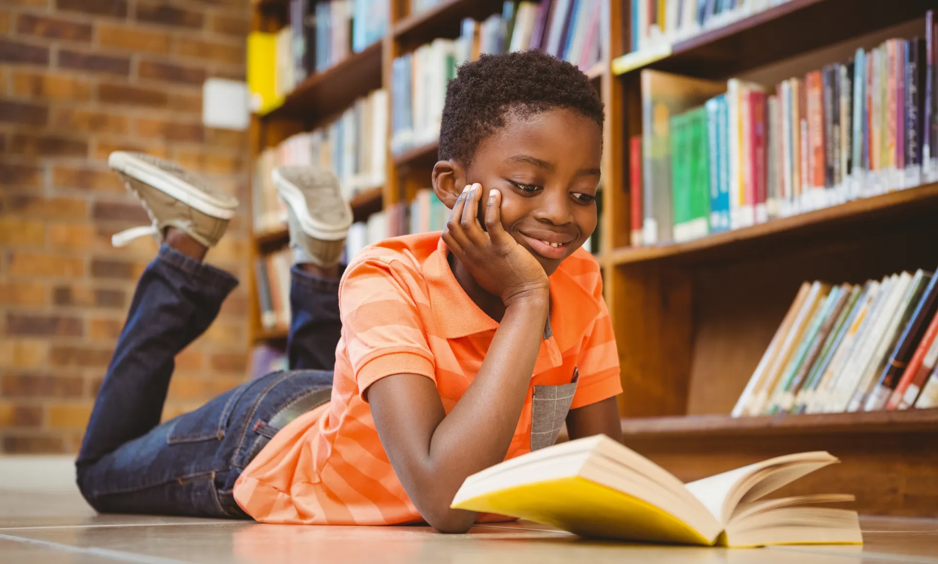 A child happily reading a book in a library